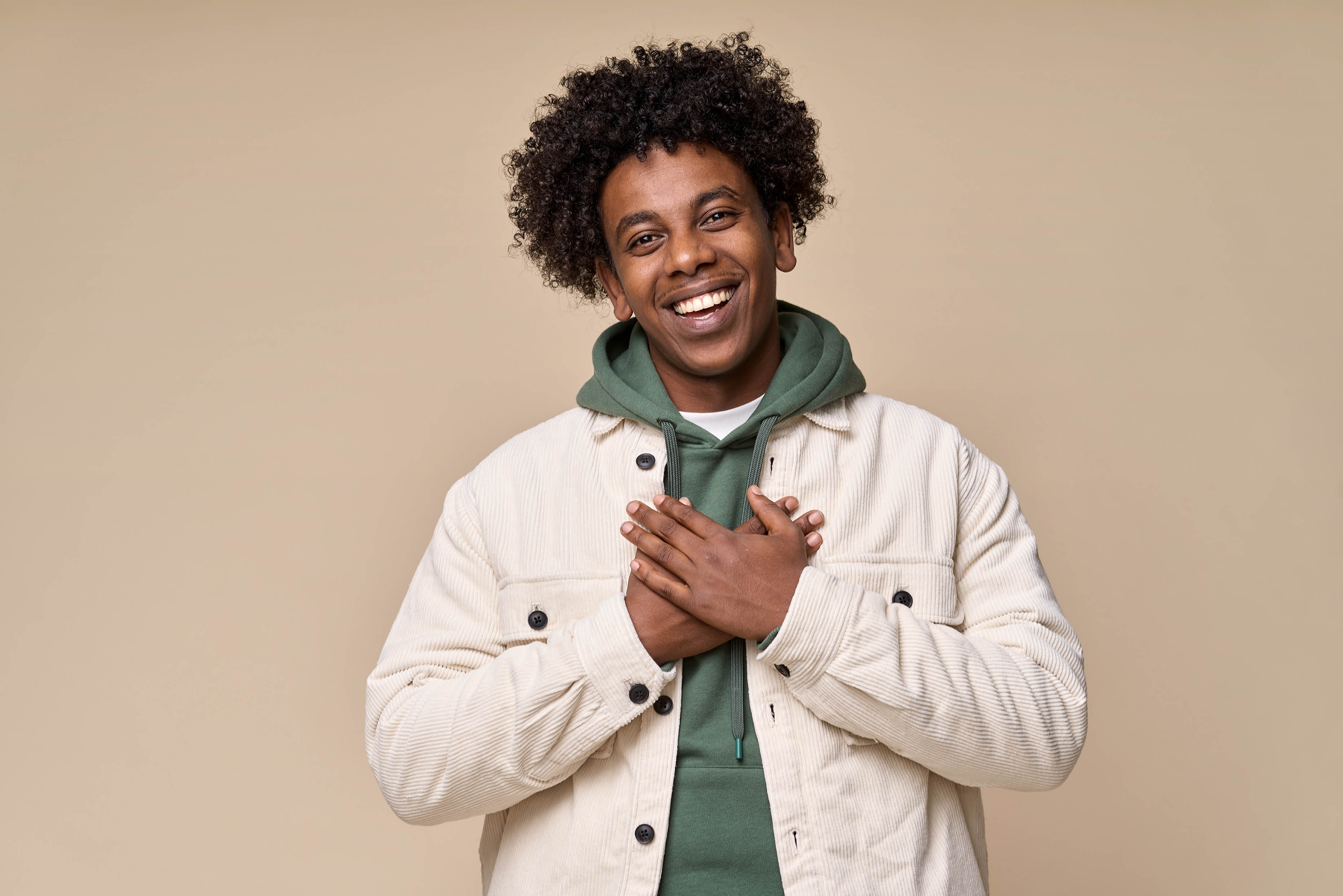 Young African American man with his hands on his heart and smiling